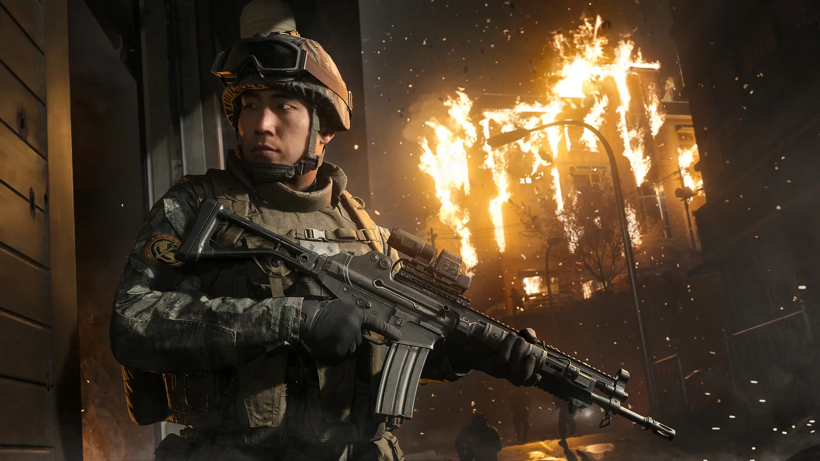 Modern Warfare 4 promotional soldier beside a burning building.